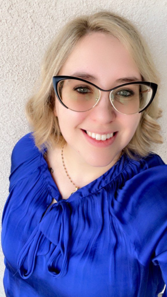 A woman with glasses smiling